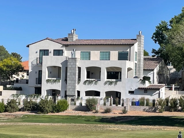 A large white house surrounded by a spacious green yard, showcasing a serene and inviting outdoor environment.